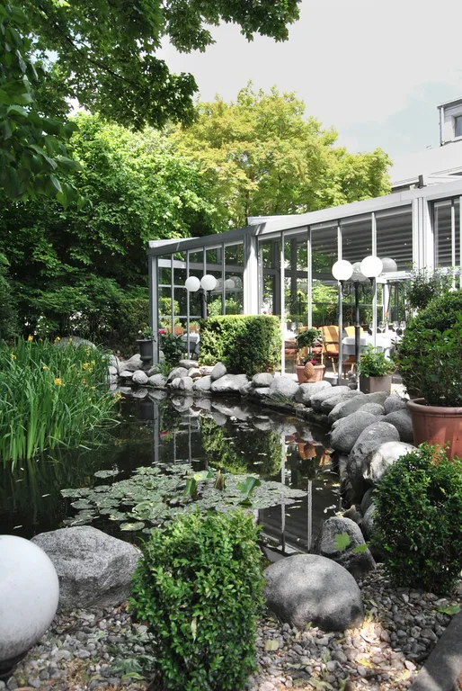 Begrünter Innenhof mit Glaswänden – der Cortile-Garten